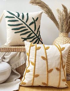 two pillows sitting on top of a wooden floor next to a basket filled with plants