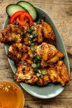 grilled chicken with tomato and cucumber garnish on a blue plate