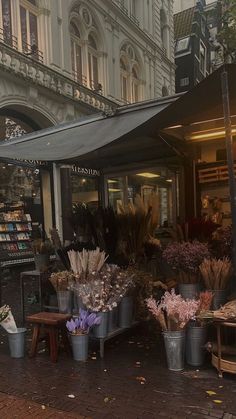 an open air market with lots of flowers in buckets