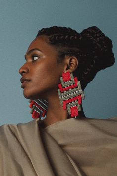 a woman wearing red and silver earrings