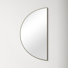 a white wall with a round mirror on it