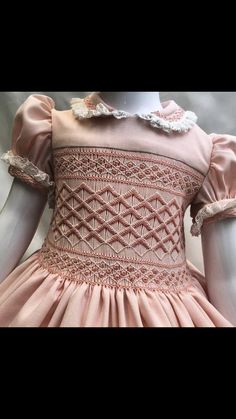 a pink dress with white lace on it