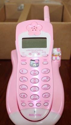 a pink toy phone sitting on top of a wooden table