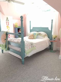 a bed room with a neatly made bed next to a window and a ceiling fan