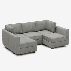 a gray sectional couch sitting on top of a white floor