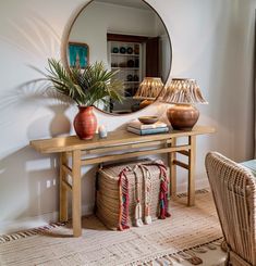 a living room with a mirror, wicker chair and potted plant on the table