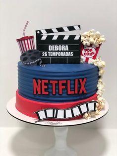 a cake that is decorated to look like a movie clapper, popcorn and soda