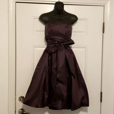 a dress hanging up on a mannequin in front of a door