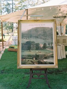 a sign in the grass that says field your seat on it and some tables with white linens