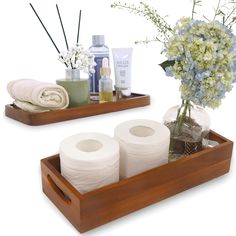 two wooden trays with toiletries and flowers in them