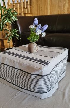 a vase with blue flowers sitting on top of a table next to a couch in a living room