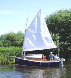 two people on a small sailboat in the water