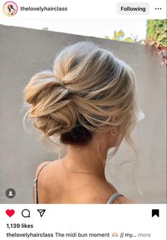 the back of a woman's head, with her hair in a low bun