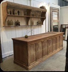 an old wooden cabinet with shelves and vases on it