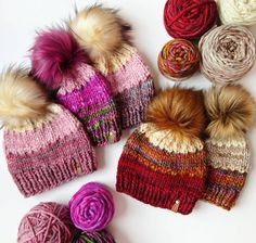 knitted hats and balls of yarn laid out on a white surface with multicolored wool