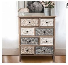 an ornate dresser with drawers and flowers on top in front of a framed horse image