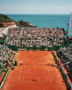 an aerial view of a tennis court with people watching from the stands and onlookers