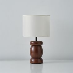 a wooden table lamp with a white shade