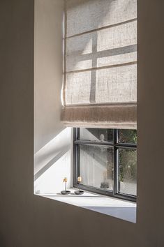 an open window with a cross on it and candles in front of the window sill