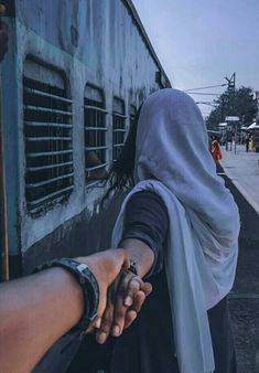 two people shaking hands in front of a train