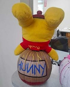 a winnie the pooh balloon sitting on top of a table next to a stuffed animal