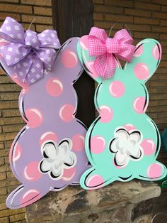 two wooden bunny ears with pink and blue polka dots, one has a purple bow