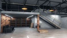 an empty warehouse with exposed brick walls and metal staircases leading up to the second floor