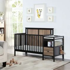 a baby crib in a room with pictures on the wall