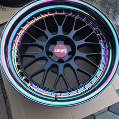 an image of a wheel that has been painted with rainbows and black spokes