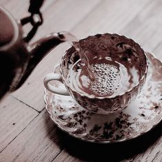 a tea cup and saucer sitting on top of a wooden table