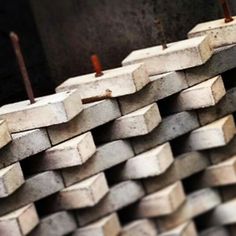 several pieces of concrete stacked together in a row with nails sticking out of the top