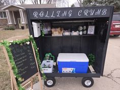 an ice chest cart with coolers on it in front of a sign and building