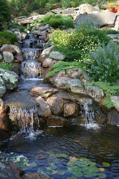 there is a small waterfall in the middle of this garden