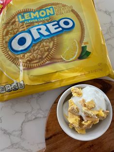 a bag of lemon flavor oreo cookies next to a bowl of ice cream on a cutting board