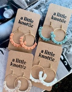 four pairs of hoop earrings are shown in front of an old car with the words little kookie written on it