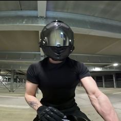 a man wearing a helmet and holding a skateboard in front of an empty parking lot