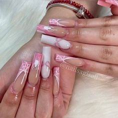 a woman's hands with pink and white nail designs on their nails, one is holding