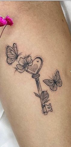 a woman's thigh with a key and butterflies on it