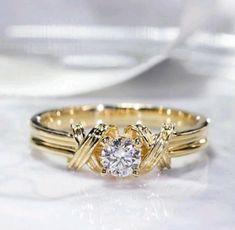 a close up of a ring with a diamond in it on a white table cloth