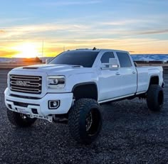 the white truck is parked on the gravel