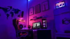 the room is lit up with purple lighting and there are pictures on the wall above the desk