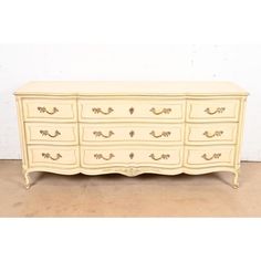 a white dresser with gold handles and drawers