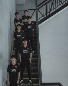 a group of young men standing next to each other on top of a set of stairs