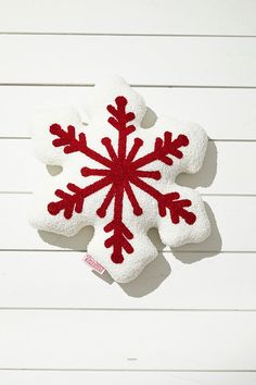 a red and white snowflake ornament hanging on a wall