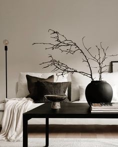 a black and white living room with two vases on the coffee table next to each other