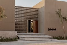 an entrance to a building with steps leading up to it and palm trees in the background