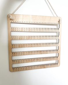 a wooden ruler hanging from a rope on a wall with white walls in the background