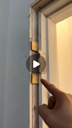 a hand pointing at the door handle on an open window