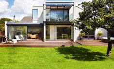 a modern house with decking and grass in the yard