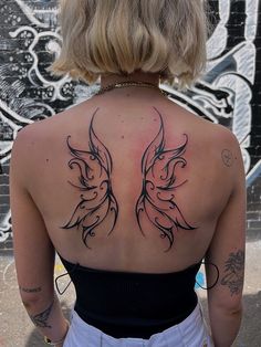 the back of a woman's neck with tattoos on it